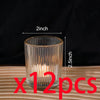 A clear glass votive candle holder with vertical stripes, shown on a wooden surface.