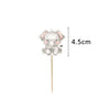 A small, cute elephant cake topper made of fondant or clay on a wooden stick.