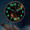 A minimalist round wall clock with glowing green hands displaying the time.