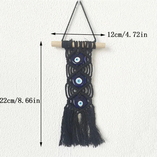 Black macrame wall hanging featuring multiple evil eye pendants on a wooden hanger.