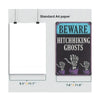 A rectangular metal tin sign with a dark background and white text that reads BEWARE HITCHHIKING GHOSTS