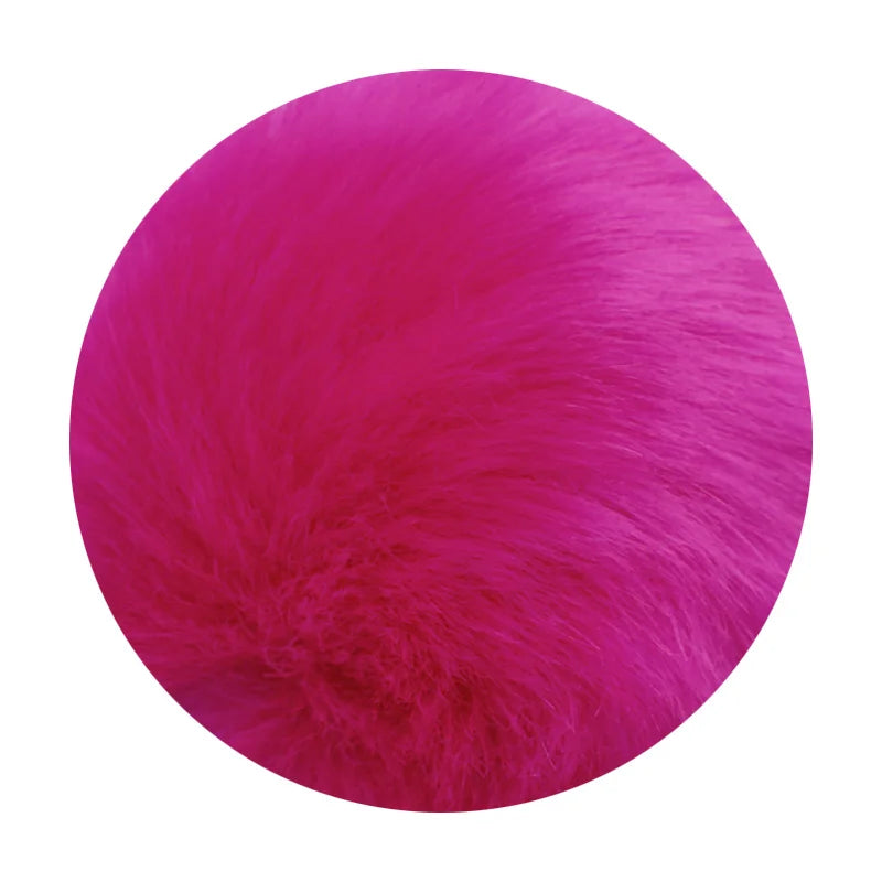 A vibrant magenta faux fur pom pom keychain attached to a silver chain.