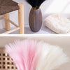 A bundle of pink and white artificial pampas grass stems in a ceramic vase for home decor