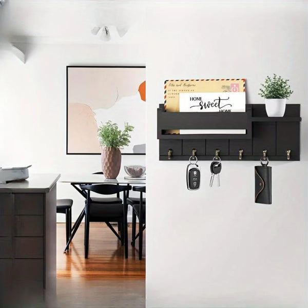 A wooden key holder with six hooks and a mail sorter displayed on a dark shelf above a modern desk.