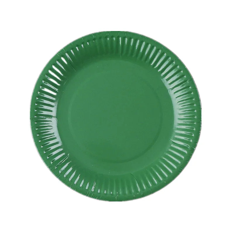 A round, dark green disposable plate with a ruffled edge.