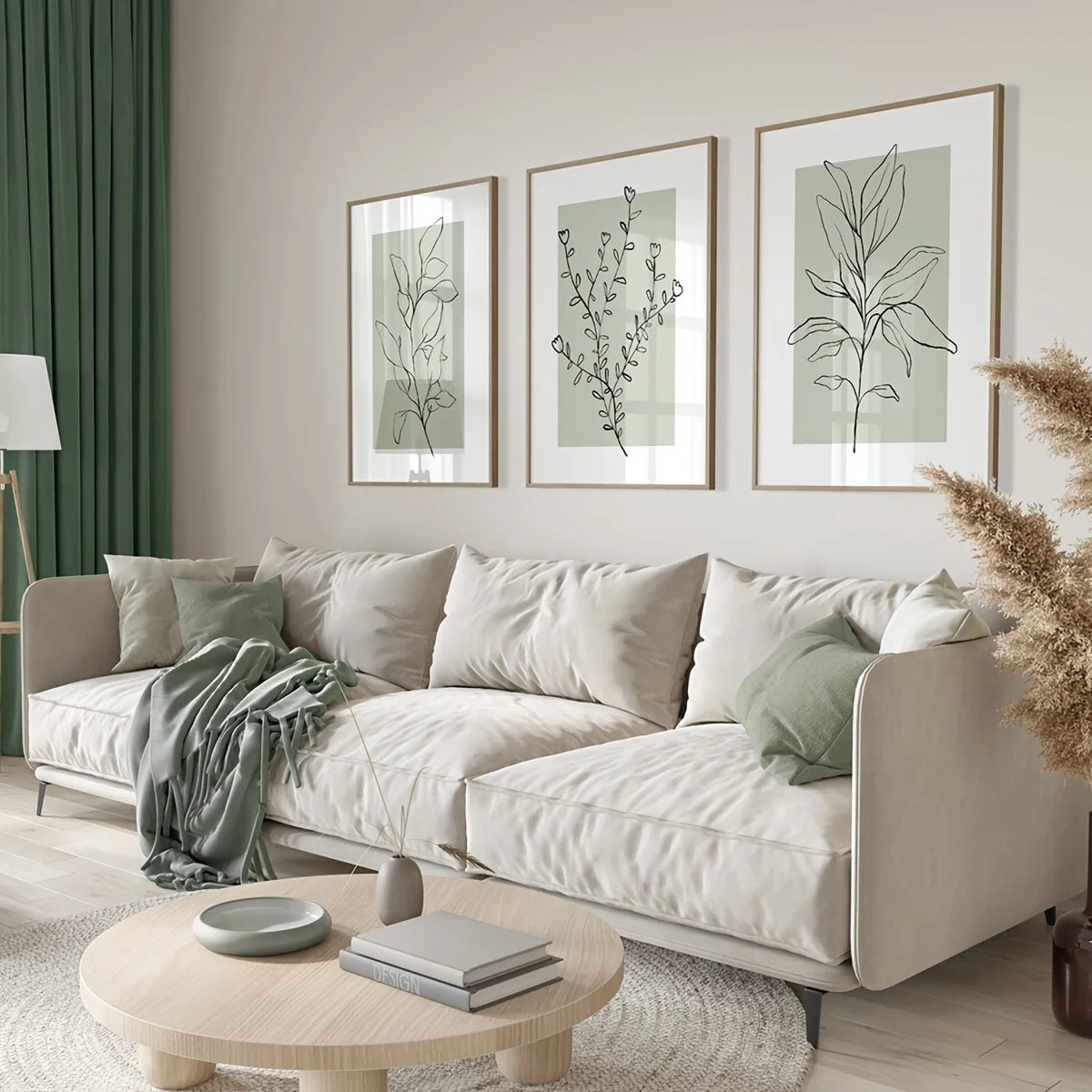 Three framed botanical prints featuring sage green floral designs displayed on a light-colored sofa.