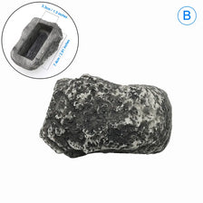 A rough, dark gray garden key hiding stone with a rectangular cavity for keys.