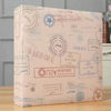A rectangular photo travel album with light pink and beige patterned paper and a textured cover.