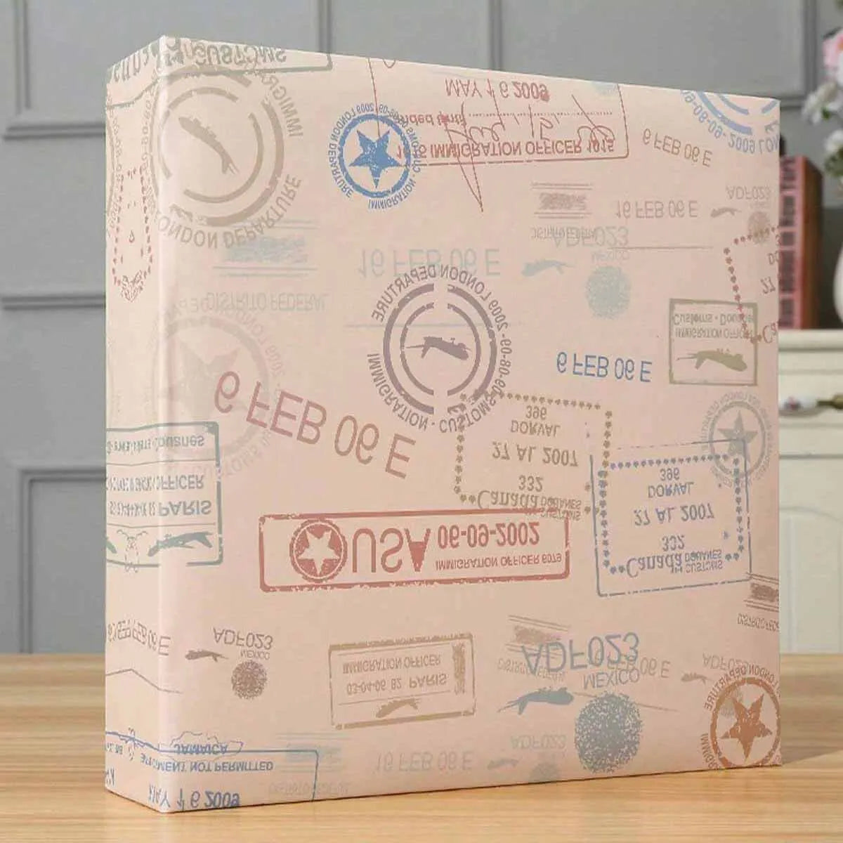 A rectangular photo travel album with light pink and beige patterned paper and a textured cover.