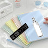A set of decorative cartoon reading bookmarks in various pastel colors and a white linen pouch are displayed on a light surfa