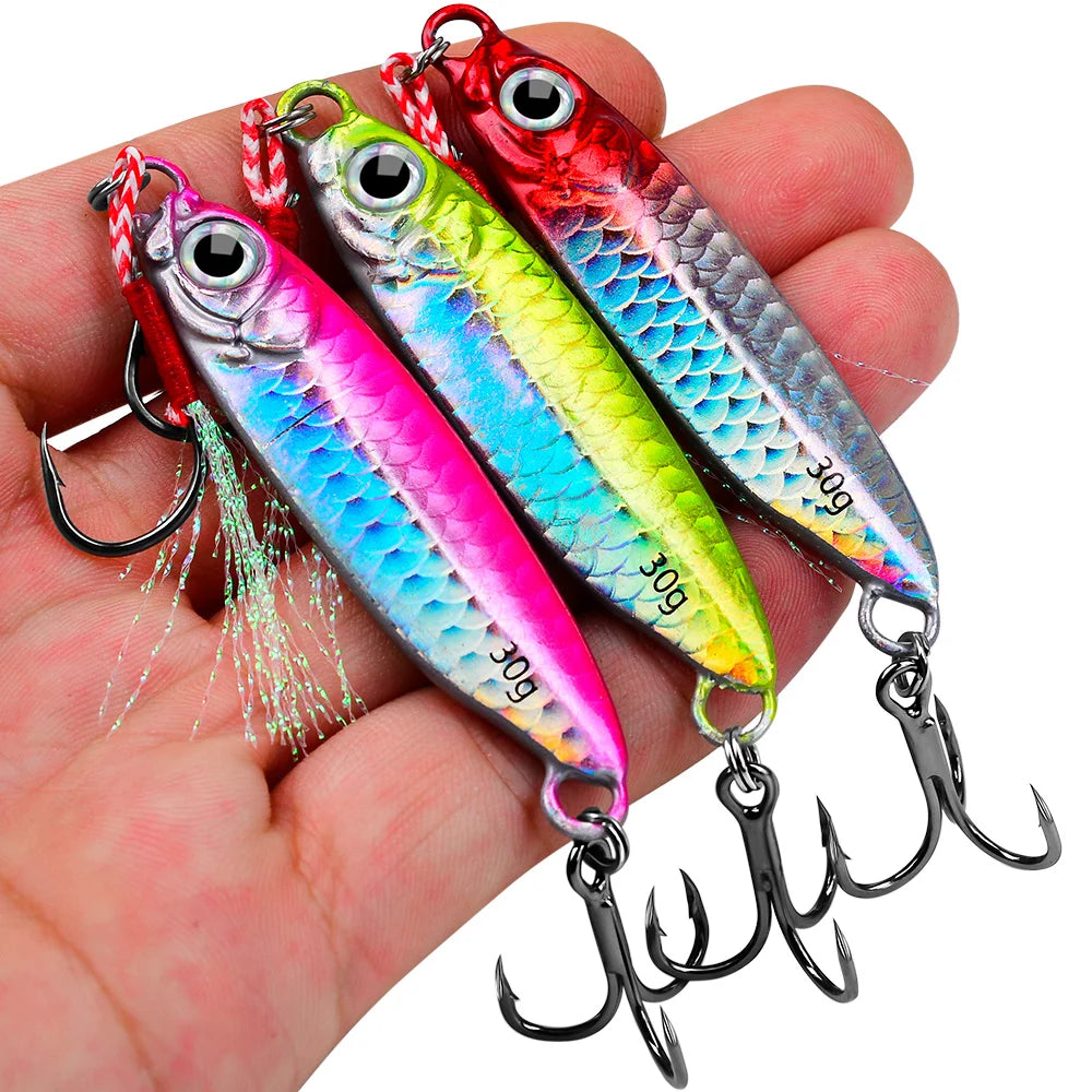 A hand holds a set of colorful metal jig fishing lures with hooks and a storage box.