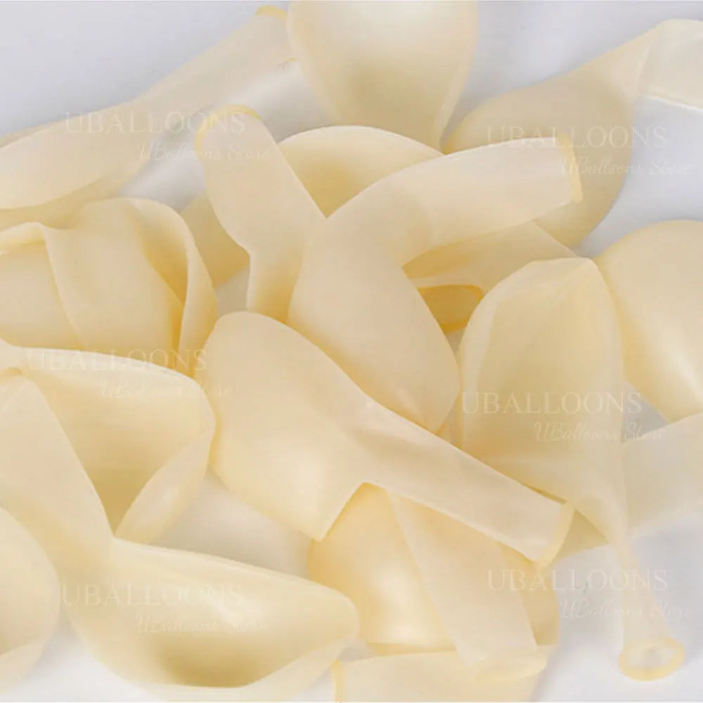 A pile of oversized clear latex balloons in a pale yellow color.