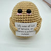 A handmade crochet baseball bat doll with a light brown body and black eyes, featuring a card that reads Life was all out of 