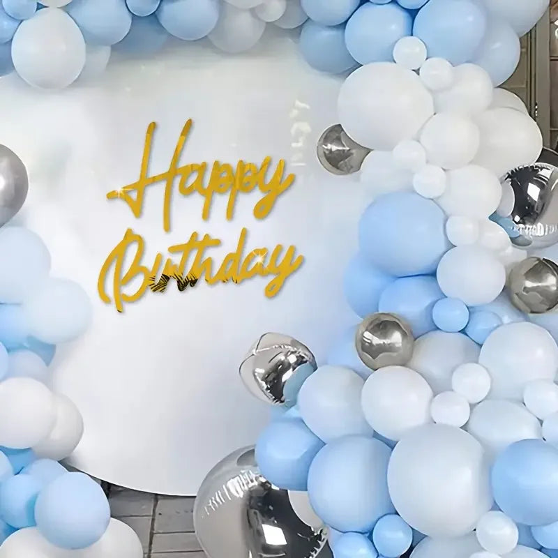 A white background decorated with blue and silver balloons and gold lettering that reads Happy Birthday