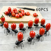 60 pieces of reusable ant-shaped plastic toothpicks and fruit forks for party snacks arranged on a wooden board.