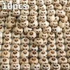 Gros plan de 10 petites citrouilles en résine sculptées au design gothique pour décoration d'Halloween extérieure.