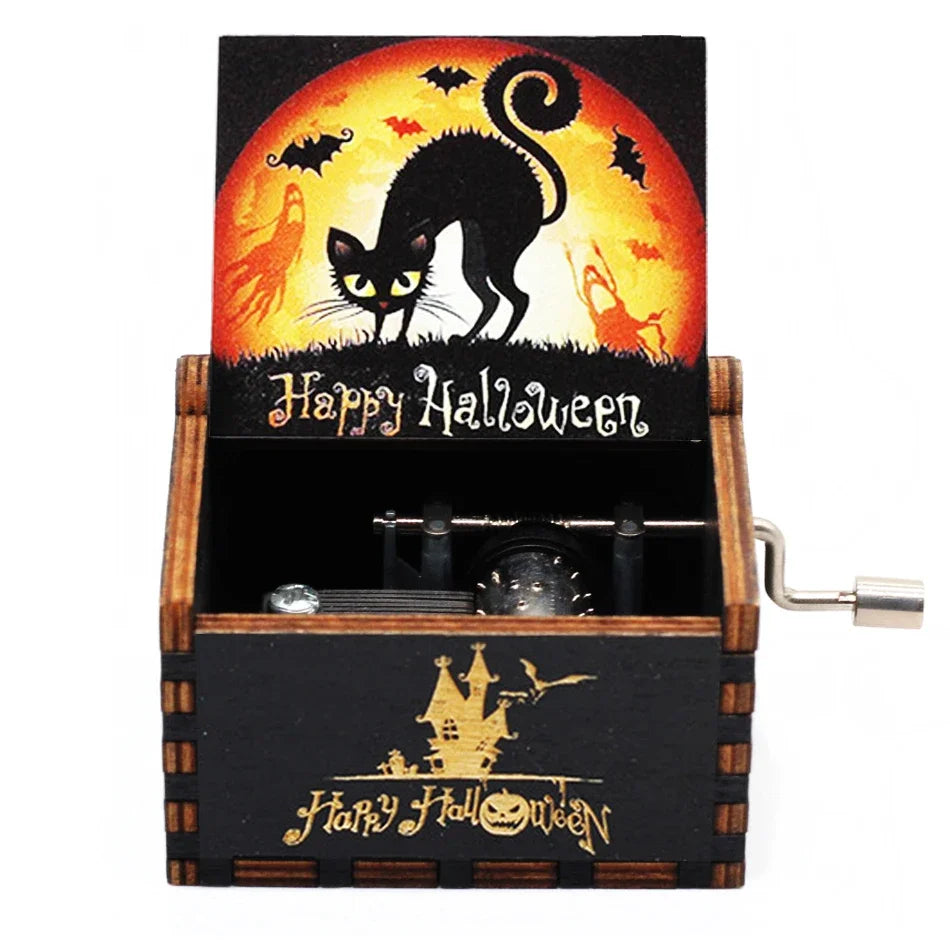 A carved wooden music box featuring a Halloween themed scene with a black cat silhouette against an orange sun background.