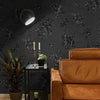 A vintage black floral self-adhesive contact paper is displayed on a dark wall next to an orange leather armchair.