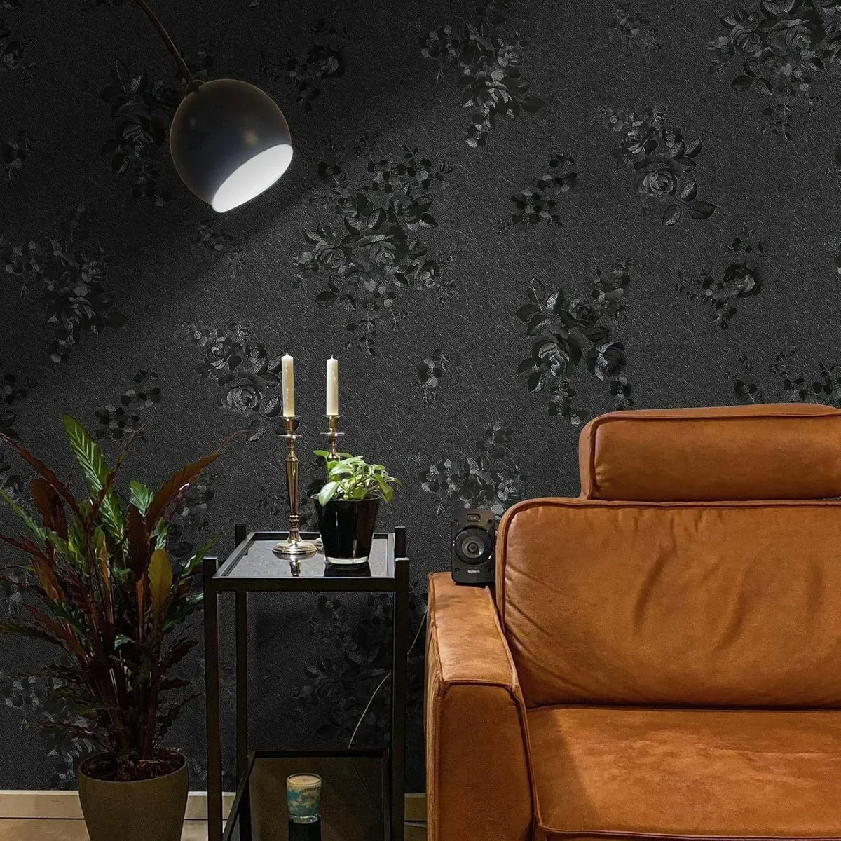 A vintage black floral self-adhesive contact paper is displayed on a dark wall next to an orange leather armchair.
