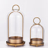 Antique brass metal candle holders with glass domes on a white background