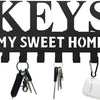 Black decorative metal wall-mounted key holder with seven hooks.