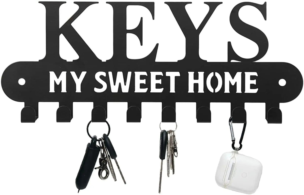 Black decorative metal wall-mounted key holder with seven hooks.