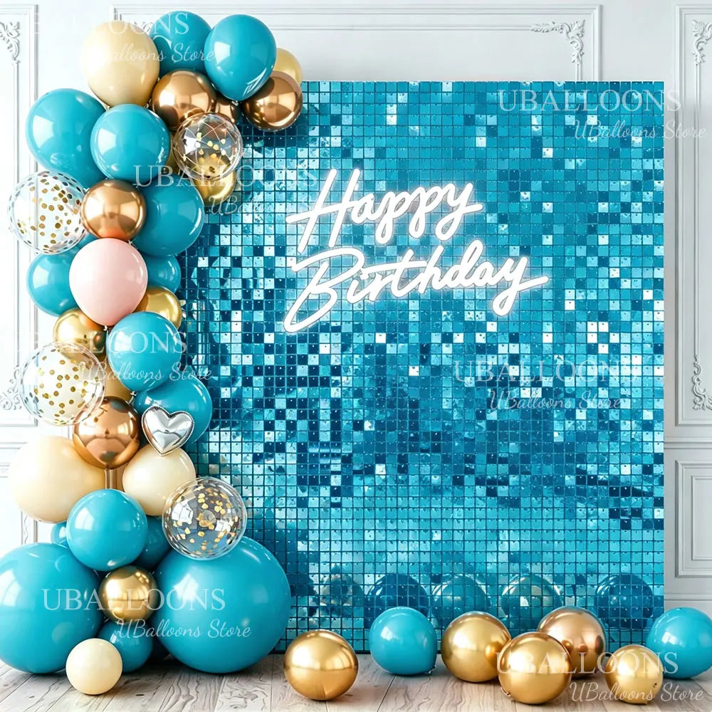 A vibrant blue glitter wall backdrop decorated with gold and teal balloons and the text Happy Birthday
