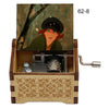 A hand-cranked wooden music box featuring a painted character and an internal mechanism.
