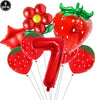 A set of red strawberry shaped balloons and a number seven balloon for a party kit