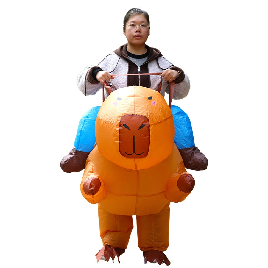 A woman is wearing an orange inflatable capybara costume with blue legs and brown ears.