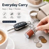 A hand holds a mini coin holder keychain with a key attached, demonstrating easy access for coins.