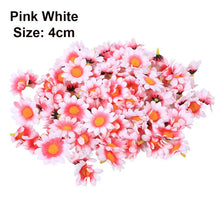 A pile of pink and white artificial sunflower and daisy heads for DIY and wedding decor.
