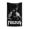 A black fabric tapestry featuring a silhouette of a figure with outstretched arms and the text YEEZUS.