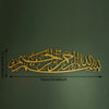 Gold metal calligraphy of Bismillah written on a dark green wall surface.