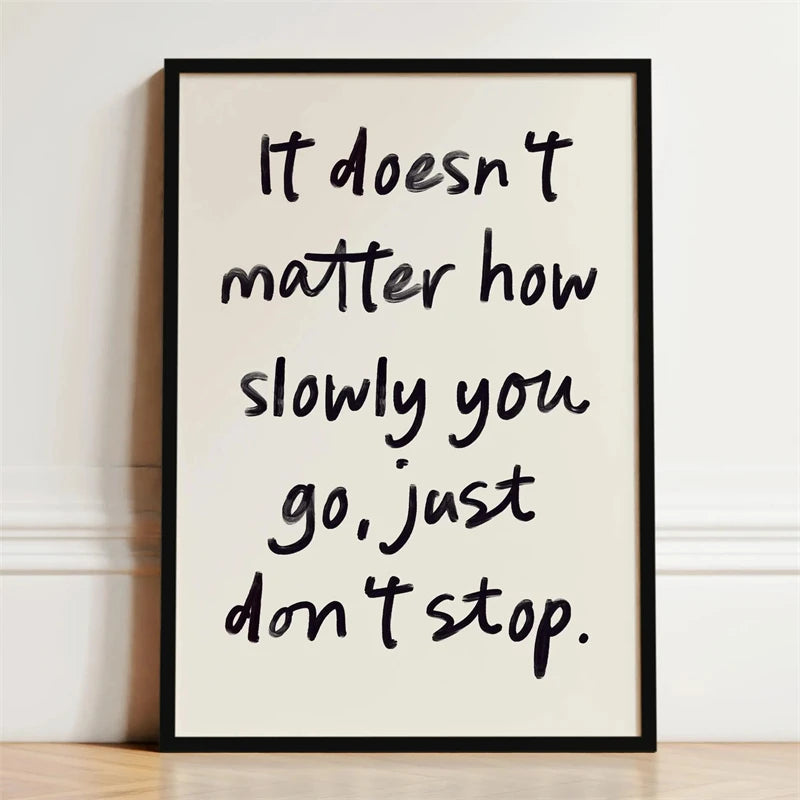 A framed black and white motivational quote print on a white background with handwritten text.