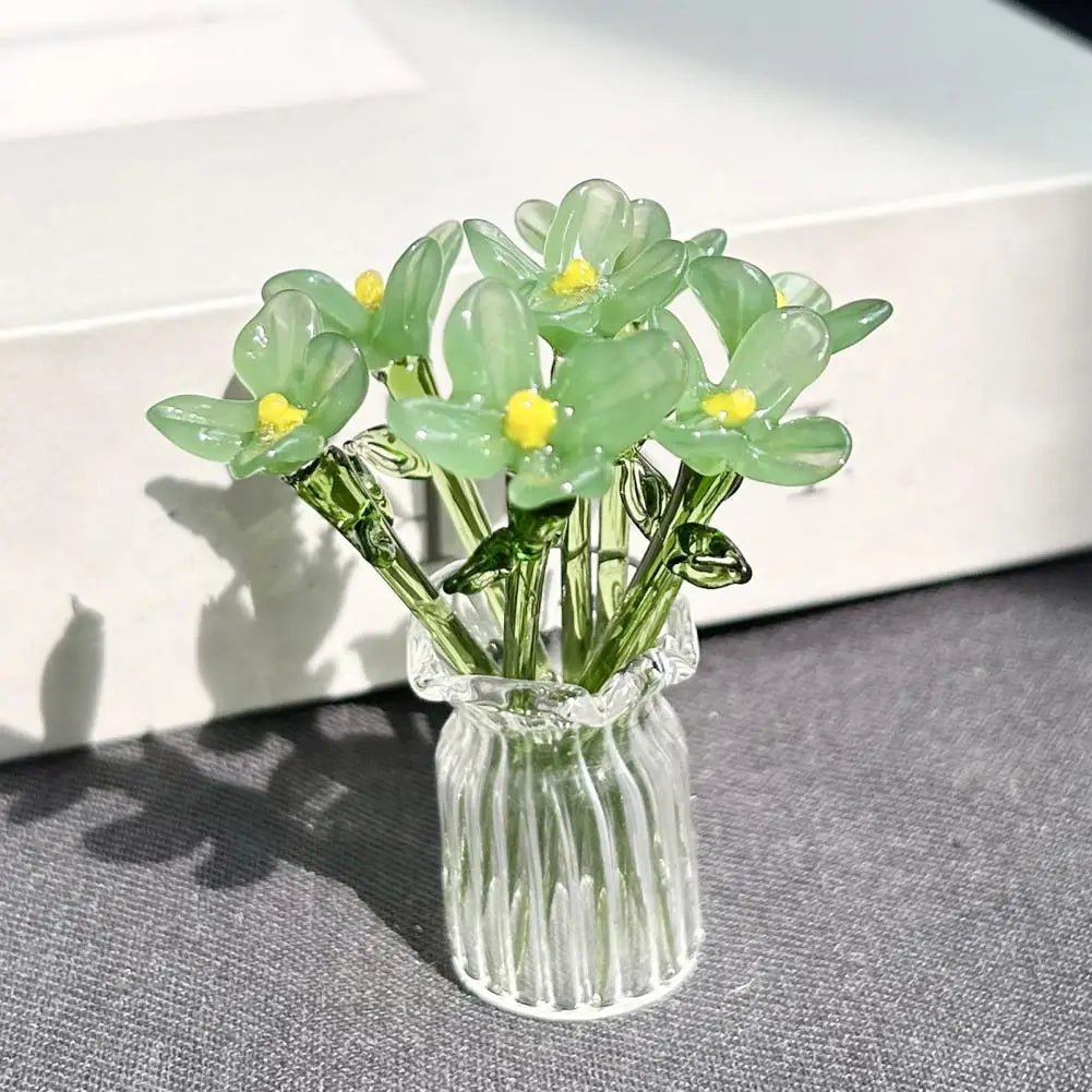 A bouquet of translucent green glass flowers in a clear glass vase