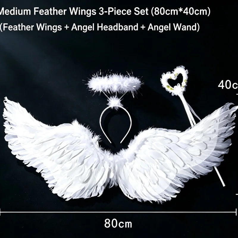 A set of white feather wings, an angel headband, and a wand displayed against a dark background.