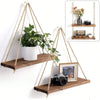 A wooden hanging shelf with hemp rope is mounted on a wall, displaying a potted plant and a camera in a floating display.