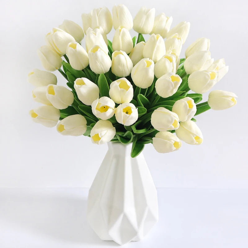 A bouquet of white artificial tulip flowers arranged in a white vase.
