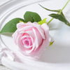 A soft pink velvet artificial rose with green leaves is displayed on a white plate.