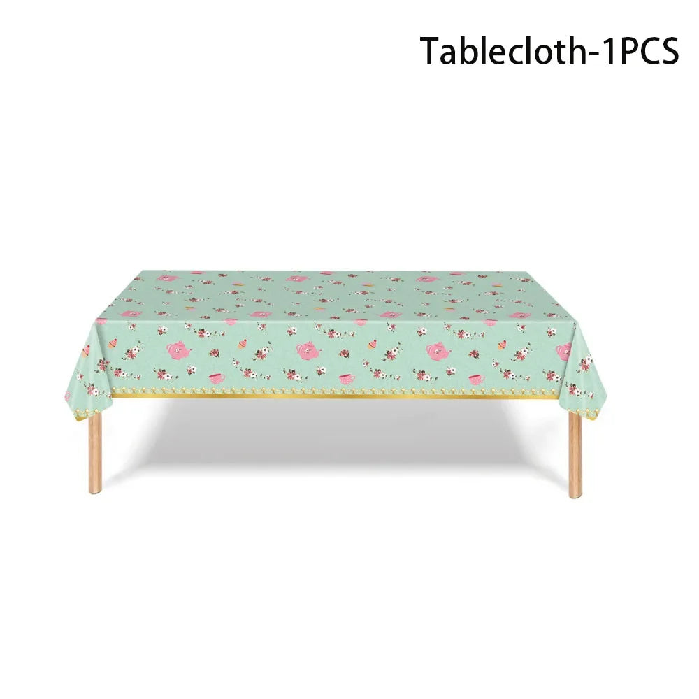 A light mint green tablecloth with a pink floral pattern displayed on a wooden table.