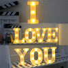 A display of glowing LED letter lights spelling out I LOVE YOU on a shelf.