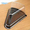 A clear disposable plastic cake slice container with a metal insert is shown on a wooden surface.