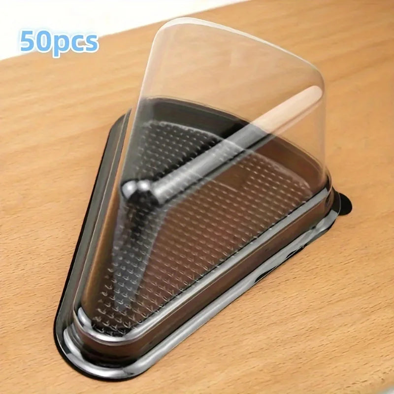 A clear disposable plastic cake slice container with a metal insert is shown on a wooden surface.