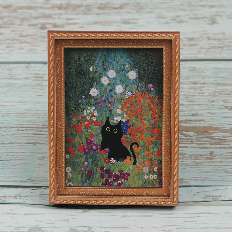 A framed painting featuring a black cat amidst colorful wildflowers and foliage.