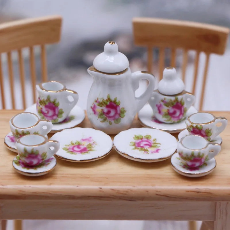 A collection of 15 miniature porcelain tea cups and a teapot set displayed on a wooden table.