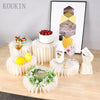 Supports en acrylique pour nourriture présentant un gâteau, une bouteille de Malibu et un verre sur une table en bois.