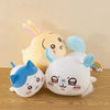 A soft yellow and blue Chiikawa Hachiware plush pillow with long ears resting on a wooden surface.