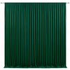 A floor-to-ceiling emerald green velvet curtain with vertical pleats used as an elegant drapery backdrop.