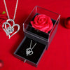 A gift set featuring a preserved red rose and a silver heart-shaped necklace displayed in a glass box.